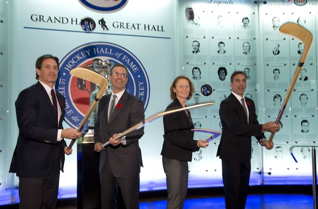 Hockey Hall of Fame inductees (left to right) Brendan Shanahan,Scott Niedermayer, Geraldine Heaney and Chris Chelios flip pucks after being presented with their rings at the Hall in Toronto on Friday November 8, 2013. THE CANADIAN PRESS/Frank Gunn