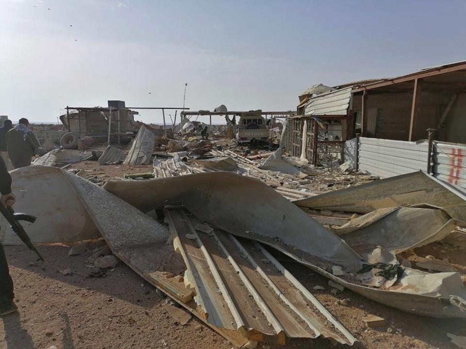 Fighters of Kataeb Hezbollah, or Hezbollah Brigades militia, inspect the destruction at their headquarters in the aftermath of a U.S. airstrike in Qaim, Iraq, Monday, Dec. 30, 2019. The Iranian-backed militia said Monday that the death toll from U.S. military strikes in Iraq and Syria against its fighters has risen to 25, vowing to exact revenge for the "aggression of evil American ravens." (AP Photo)