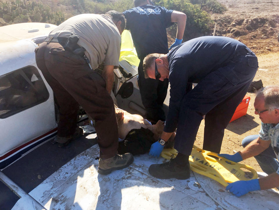 This photo provided by the Los Angeles County Sheriff's Department shows first responders extricating one of the injured from a plane that crashed at the airport near Avalon on Santa Catalina Island off the Southern California coast Wednesday, July 25, 2018. Three people were injured, one severely in th 9:30 a.m. crash. The single-engine Piper PA-32 went off the runway after landing, FAA spokesman Ian Gregor said. (Los Angeles County Sheriff's Department via AP)