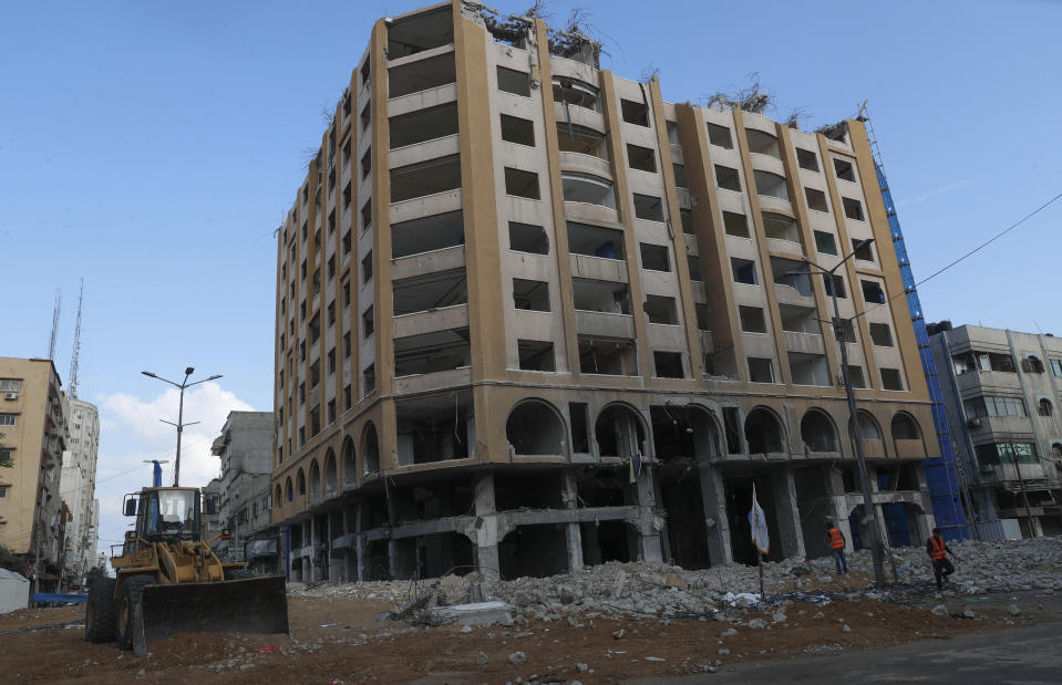 Palestinian workers use heavy equipment to break and remove parts of the Al-Jawhara building, which was targeted by Israeli airstrikes during Israel's war with Gaza's Hamas rulers last May, in the central al-Rimal neighborhood of Gaza City, Oct. 20, 2021. The Gaza Strip has few jobs, little electricity and almost no natural resources. But after four bruising wars with Israel in just over a decade, it has lots of rubble. Local businesses are now finding ways to cash in on the chunks of smashed concrete, bricks and debris left behind by years of conflict. (AP Photo/Adel Hana)