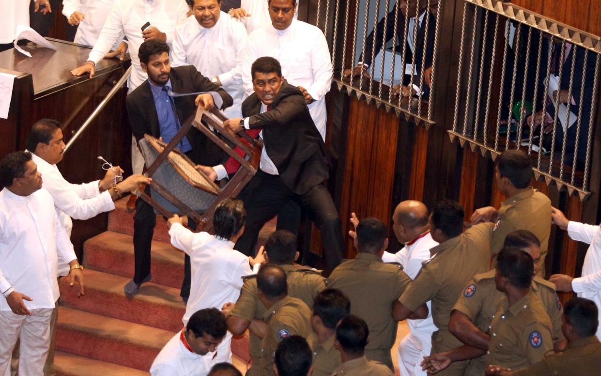 Parliament member Johnston Fernando, who is backing newly appointed prime minister Mahinda Rajapaksa, throws a chair at police  - REUTERS