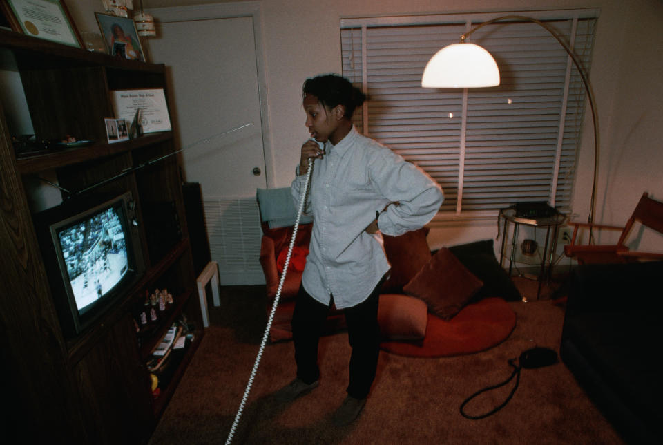 A woman is talking on the phone while watching TV