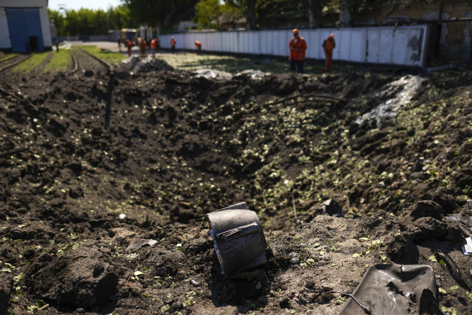 A piece of a rocket lies next a crater after a Russian strike in Pokrovsk, eastern Ukraine, Wednesday, May 25, 2022. Two rockets struck the eastern Ukrainian town of Pokrovsk, in the Donetsk region early Wednesday morning, causing at least four injuries. (AP Photo/Francisco Seco)