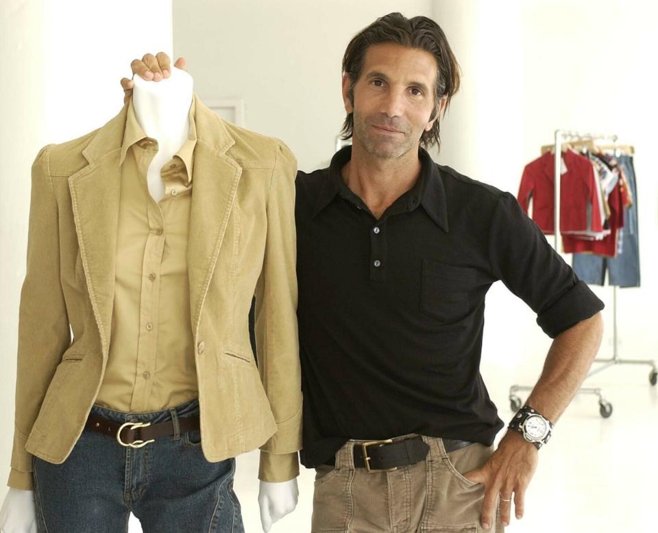 FILE - This May 15, 2002 file photo shows Los-Angeles based clothing designer Mossimo Giannulli posing with his fall preview clothing for Target department stores in New York. Giannulli and his wife, actress Lori Loughlin were charged along with nearly 50 other people Tuesday in a scheme in which wealthy parents bribed college coaches and other insiders to get their children into some of the most elite schools in the country, federal prosecutors said. (AP Photo/Kathy Willens, File)