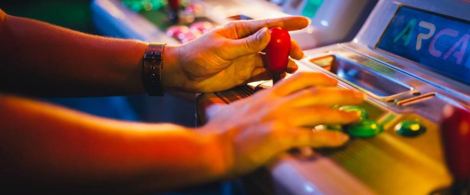 Hands with Arcade Joystick Playing Old Arcade Video Game