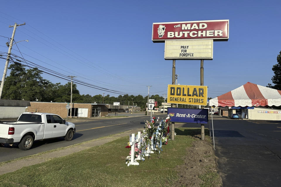 Memorials sit by the parking lot of the Mad Butcher grocery store in Fordyce, Ark., Tuesday, July 2, 2024. The store reopened 11 days after a shooter killed four people and injured 10 others in the store and its parking lot. (AP Photo/Andrew DeMillo)