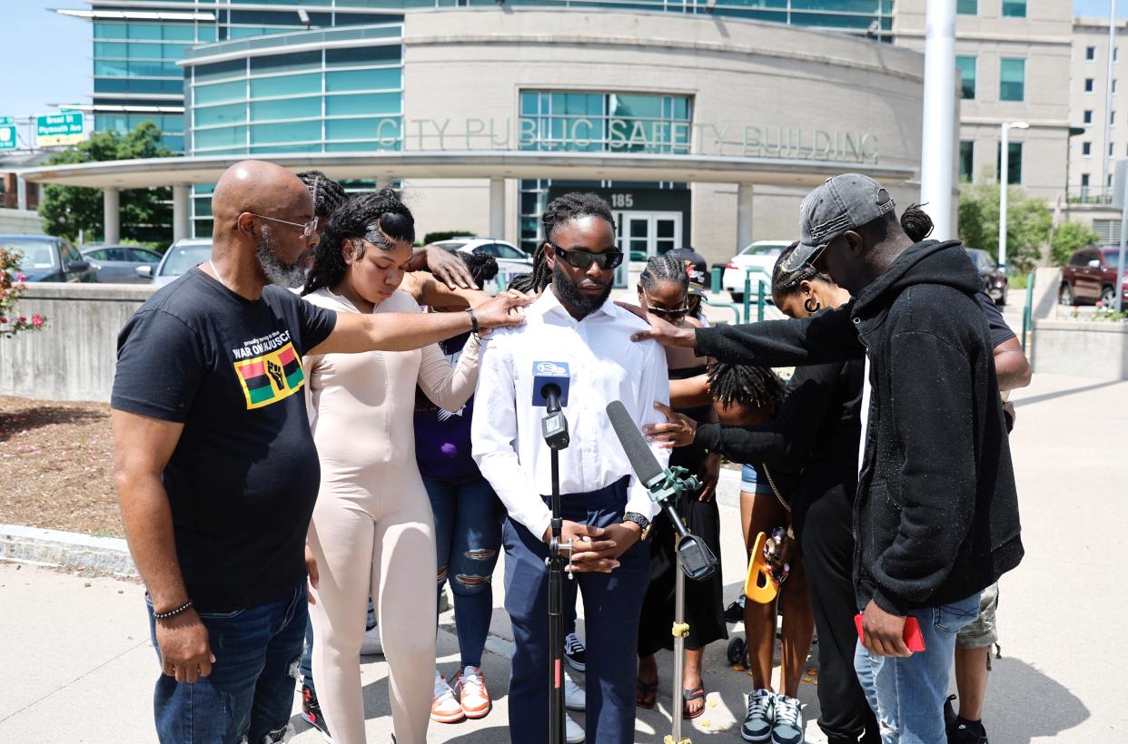 Community members pray for Marvin Taylor at the end of a news conference June 13 outside the public safety building.