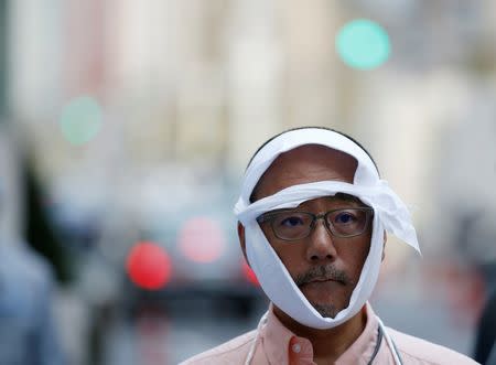 A man role-playing as an injured person takes part in a drill simulating a 7.2 magnitude earthquake in Tokyo, Japan, August 26, 2016. REUTERS/Kim Kyung-Hoon