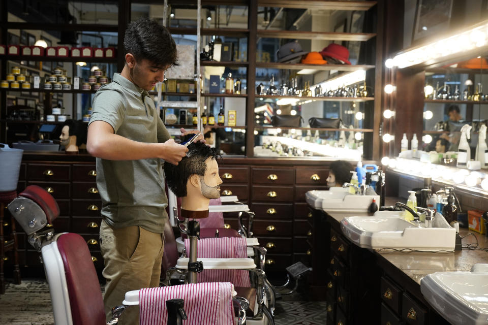 MANCHESTER, UNITED KINGDOM - JULY 02: Apprentice barber Sam Scott practices his scissor skills on a mannequin ahead of the Barber Barber salon opening by appointment on Saturday. July 02, 2020 in Manchester, United Kingdom. Many more retailers are reopening with social distancing measures after being shuttered for months due to the Covid-19 pandemic. Pubs and restaurants can fully reopen in England from July 4th. (Photo by Christopher Furlong/Getty Images)