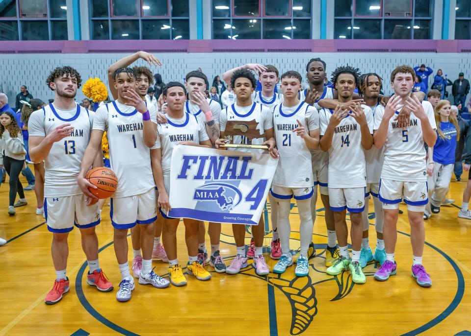 The Wareham boys basketball team takes a moment to pose with the Final Four banner and trophy after the Vikings defeated Lynn Voc-Tech in convincing fashion on Friday evening at Wareham High School.