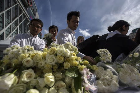 People place flowers for victims killed in Monday's bomb blast during a religious ceremony near at the Erawan shrine, the site of Monday's deadly blast, in central Bangkok, Thailand, August 21, 2015. REUTERS/Athit Perawongmetha