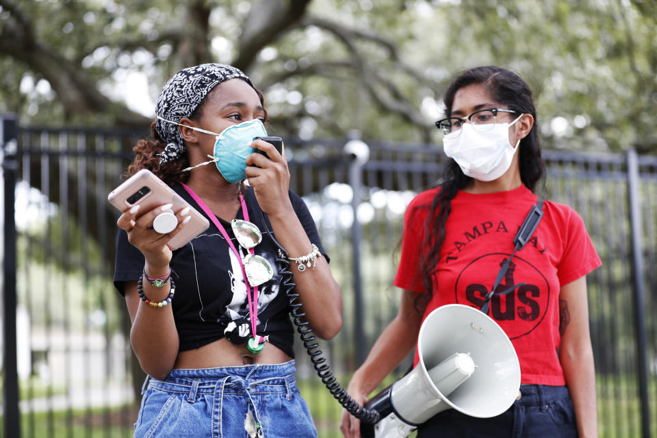 TAMPA, FL - JULY 02: University of South Florida students Makyla Burks, (L) and Eithne Silva both wear face masks while protesting in front of the Lifsey residence where the USF President Steven Currall lives on campus on July 2, 2020 in Tampa, Florida. Tampa Bay Students for Democratic Society protest at the University of South Florida demanding an increase in Black student enrollment, employ more Black faculty and staff, more financial aid, and make direct connections with the surrounding community. (Photo by Octavio Jones/Getty Images)