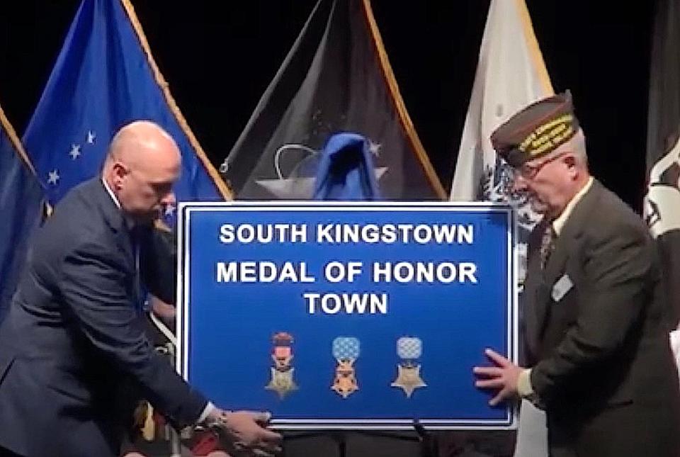 South Kingstown Town Manager James Manning, left, and  Joe “Tiger” Patrick, commander of the Veterans of Foreign Wars in RI, present the “Medal of Honor Town” sign to the community.