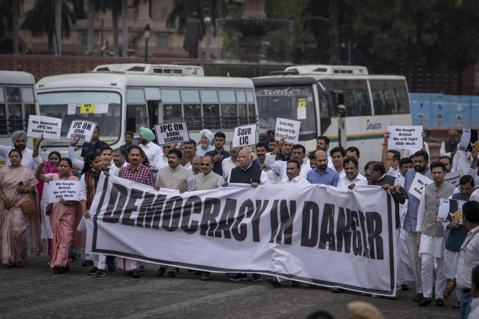 Lawmakers from India's opposition Congress and other parties hold a banner as they march against the Narendra Modi-led government alleging that Indian democracy is in danger, during a protest outside India's parliament in New Delhi, India, Friday, March 24, 2023. Key Indian opposition Congress party leader Rahul Gandhi lost his parliamentary seat as he was disqualified following his conviction by a court that found him of guilty of defamation over his remarks about Prime Minister Narendra Modi's surname, a parliamentary notification said on Friday. (AP Photo/Altaf Qadri)