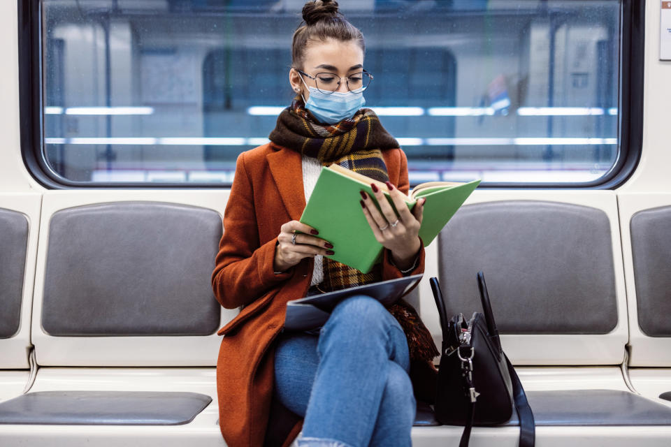 Woman reading a book on the subway