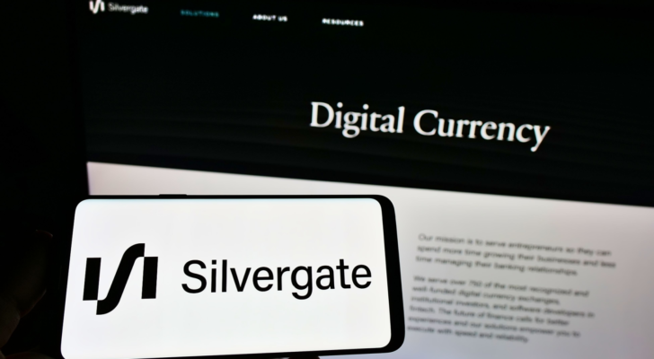 Person holding smartphone with logo of US financial services company Silvergate Bank (SI) on screen in front of website. Focus on phone display. Unmodified photo.