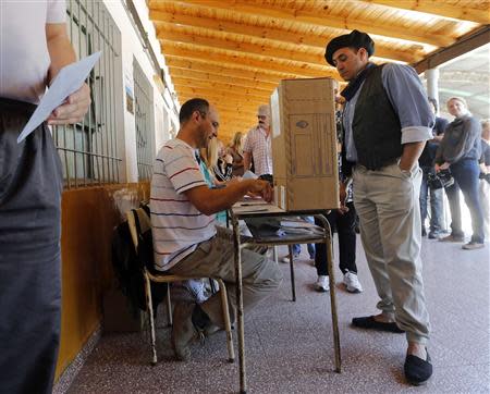 A man waits to vote for the legislative election in Tigre October 27, 2013. REUTERS/Enrique Marcarian