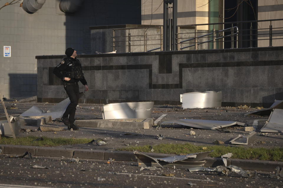 A police officer passes by debris of a building following Russia's missile attack in Kyiv, Ukraine, Friday, Dec. 29, 2023. Russia launched about 110 missiles as well as drones against Ukrainian targets during the night Ukraine President Volodymyr Zelenskyy said Friday, in what appeared to be one of the biggest aerial barrages of the 22-month war. (AP Photo/Efrem Lukatsky)