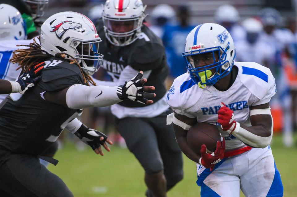 Pahokee running back Jashon Benjamin (1) runs down the field under pressure from Palm Beach Central's Agustus Mckoy (58) in the first half at Palm Beach Central on Sept. 16 in Wellington.