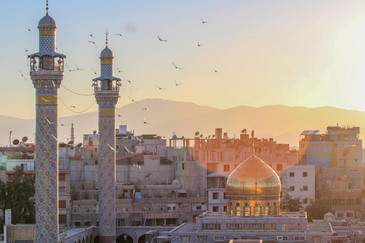 External shot for Sayeda Zeinab shrine in Damascus capital of Syria, which showing the shrine with one golden dome and two minarets and some Residential buildings.