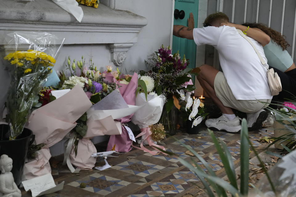 A couple embrace at the Paddington residence of Jesse Baird in Sydney, Tuesday, Feb. 27, 2024. Police on Tuesday discovered the bodies of former television reporter Jesse Baird, 26, and his flight attendant partner Luke Davies, 29, who were allegedly shot dead in Baird's Sydney home on Monday last week. (AP Photo/Mark Baker)