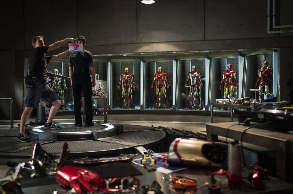 The first official photo from the set of "Iron Man 3" was released today, and it shows Tony Stark (Robert Downey Jr.) reunited with his seven best friends -- his armored suits.<br><br> The still shows Downey on the set of Stark's workshop preparing to film (it's scene 24F according to the slate the camera assistant is holding). Downey is facing his collection of Iron Man suits, which has been expanded since the last movie. In "Iron Man 2," his shop only featured four suits, but now it includes the ones he wears in "The Avengers." <br><br><a href="http://l.yimg.com/os/251/2012/06/04/im3-jpg_192905.jpg" rel="nofollow noopener" target="_blank" data-ylk="slk:View the full size photo >>;elm:context_link;itc:0;sec:content-canvas" class="link ">View the full size photo >></a><br><br> Photographers have already snapped pics of one of the villains in the movie, the Iron Patriot, who wears a suit like Stark's but decked out in red, white and blue colors. It's also been rumored that the new movie will take cues from the "Extremis" comic book storyline, which involved Tony being injected with nanotechnology that actually makes him part machine. So it's safe to assume he'll get a upgrade for this next outing as well.<br><br> With that in mind, take a closer look at each of the mechanized suits Tony Stark has sported and how the look and technology behind them evolved through the movies.