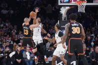 New York Knicks guard Evan Fournier (13) shoots against Brooklyn Nets center Andre Drummond (1) during the first half of an NBA basketball game, Wednesday, Feb. 16, 2022, in New York. (AP Photo/John Minchillo)