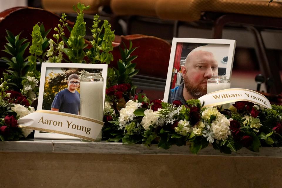 Photos of Aaron Young and his father, William Young, are displayed at a vigil for the victims of Wednesday's mass shootings at the Basilica of Saints Peter and Paul, Sunday, Oct. 29, 2023, in Lewiston, Maine. (The Associated Press)