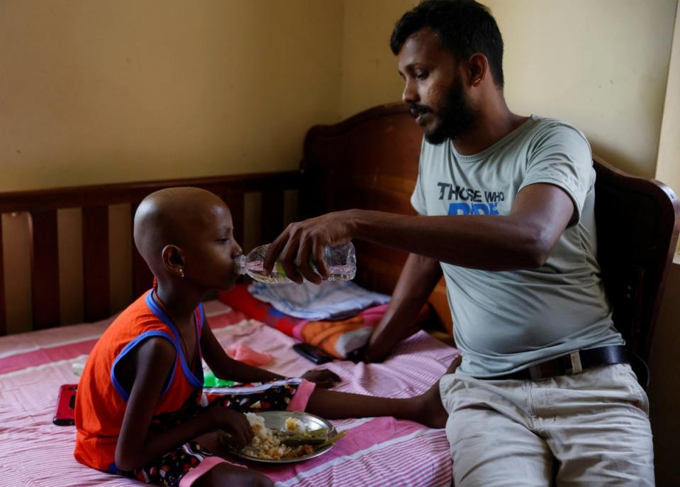 Periyathambi Rathis gives water to his daughter Rathis Supiksa (Reuters)