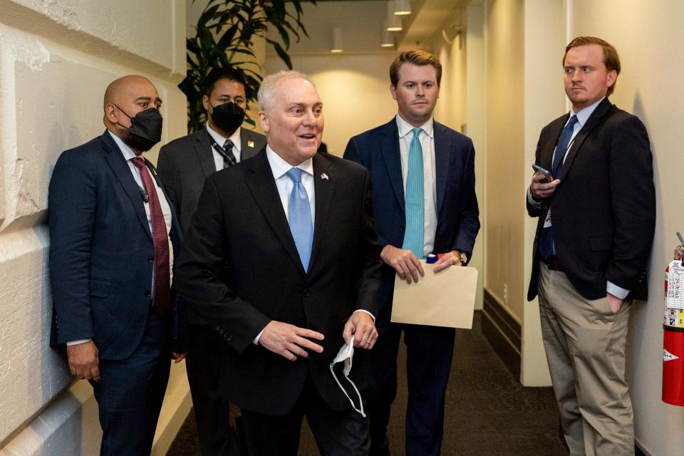 Rep. Steve Scalise, R-La., pulls off his mask before speaking to reporters after meeting with other GOP members.