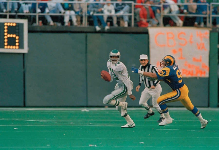 Philadelphia Eagles quarterback Randal Cunningham highsteps his way to an eighteen yard gain and a first down at Los Angeles Rams’ Fred Strickland tries to tackle him during third quarter NFL action at Philadelphia’s Veterans Stadium, Nov. 6, 1988. (AP Photo/Rusty Kennedy)