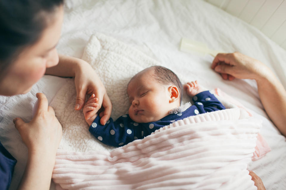 Mum holding newborn baby's hand. (Getty Images)