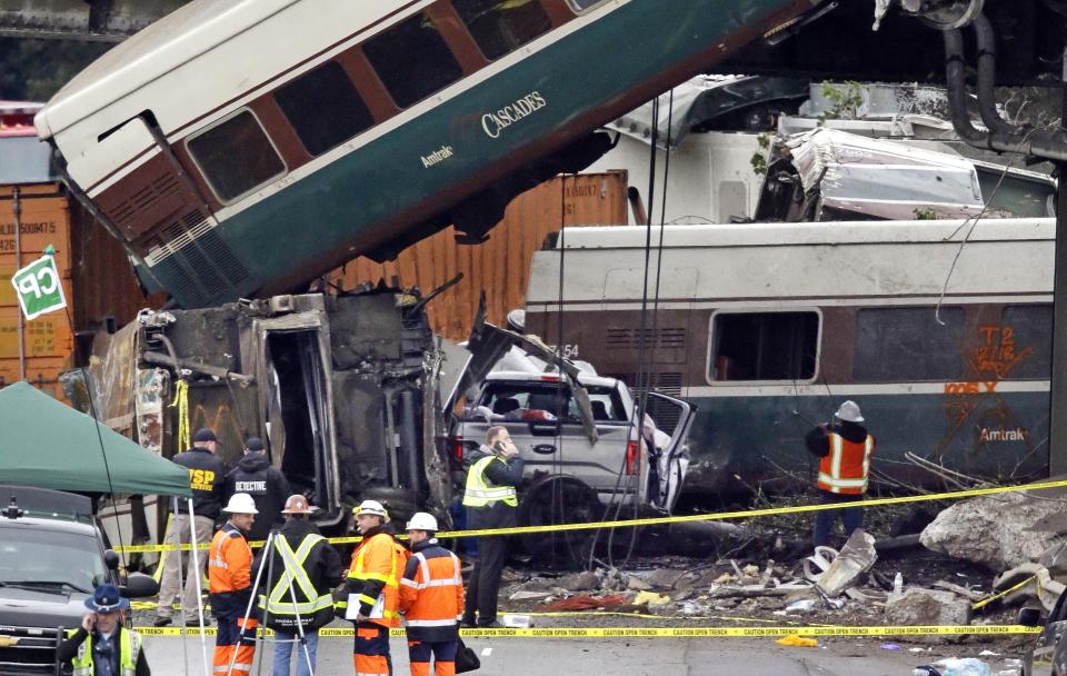 Cars from an Amtrak train that derailed above lay spilled onto Interstate 5 alongside smashed vehicles, in DuPont, Wash. The Amtrak train making the first-ever run along a faster new route hurtled off the overpass Monday near Tacoma and spilled some of its cars onto the highway below, killing some people, authorities said — Shutterstock/AP