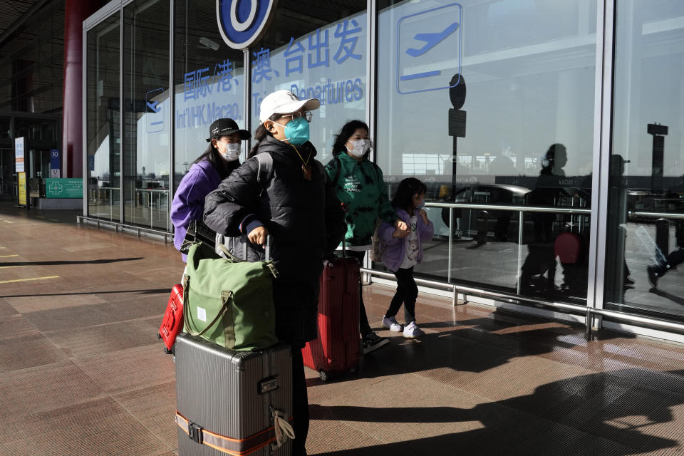 FILE - Passengers wearing masks arrive at the Capital airport terminal in Beijing on Dec. 13, 2022. Companies welcomed China’s decision to end quarantines for travelers from abroad as an important step to revive slumping business activity while Japan on Tuesday, Dec. 27, announced restrictions on visitors from the country as infections surge. (AP Photo/Ng Han Guan, File)