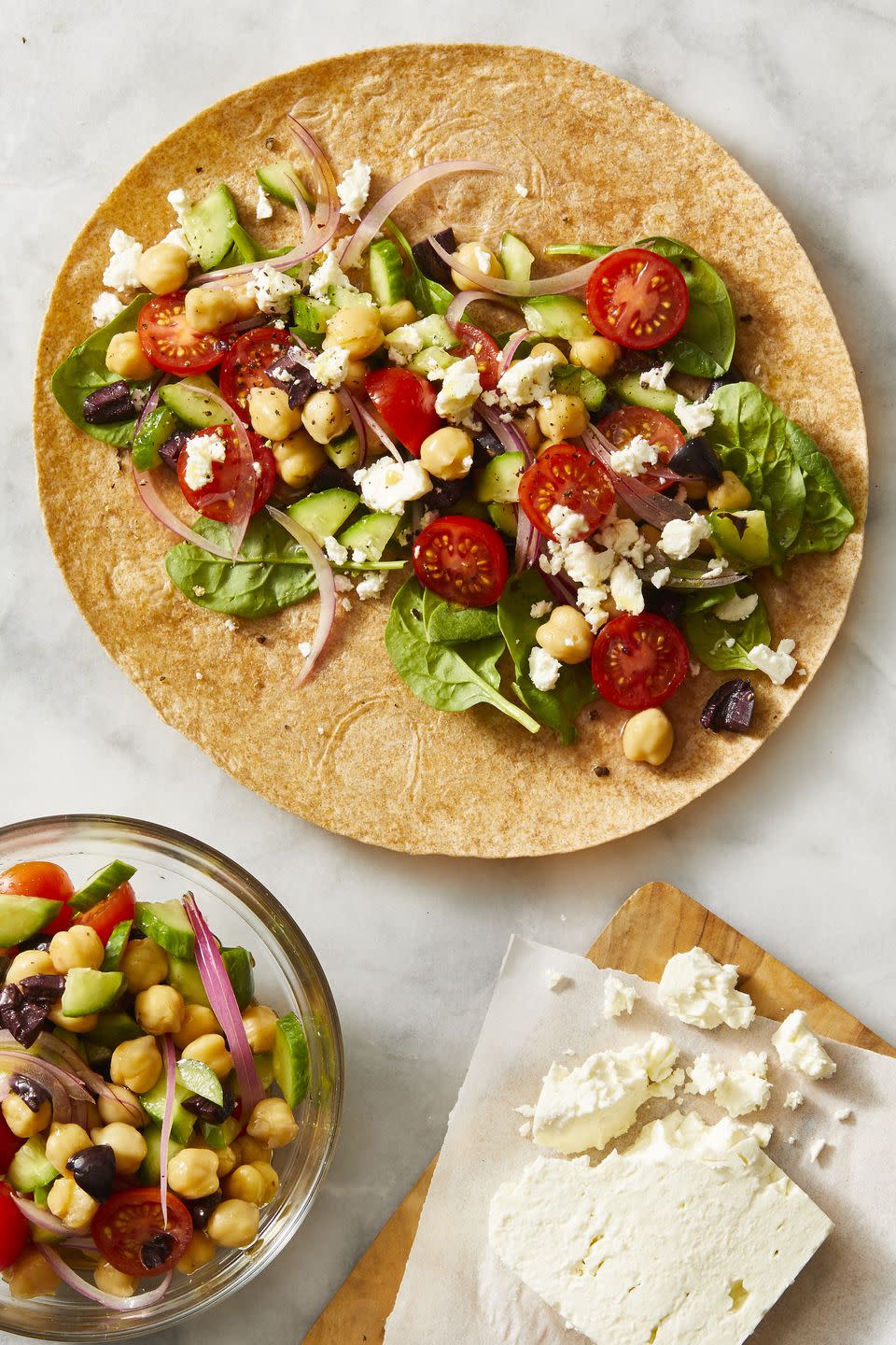 greek salad in a wrap with feta cheese crumbled on top