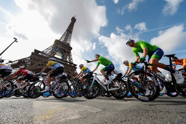 El pelotón de ciclistas pasa por la Torre Eiffel al inicio de la carrera de ruta 