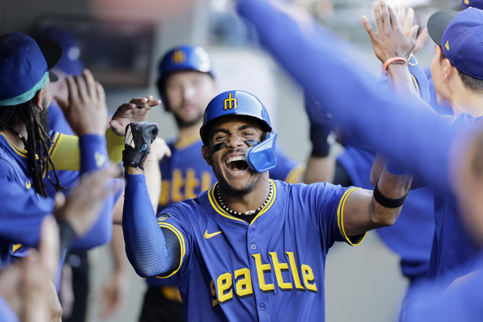 Seattle Mariners' Julio Rodriguez celebrates in the dugout after scoring against the Toronto Blue Jays in a baseball game, Friday, July 5, 2024, in Seattle. (AP Photo/John Froschauer)