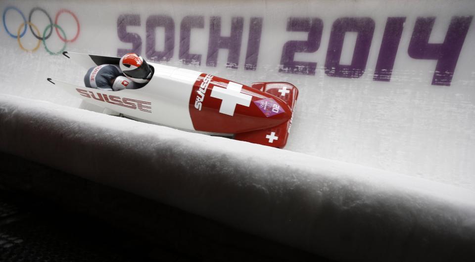 The team from Switzerland SUI-1, piloted by Beat Hefti and brakeman Alex Baumann, take a curve during the men's two-man bobsled competition at the 2014 Winter Olympics, Sunday, Feb. 16, 2014, in Krasnaya Polyana, Russia. (AP Photo/Natacha Pisarenko)