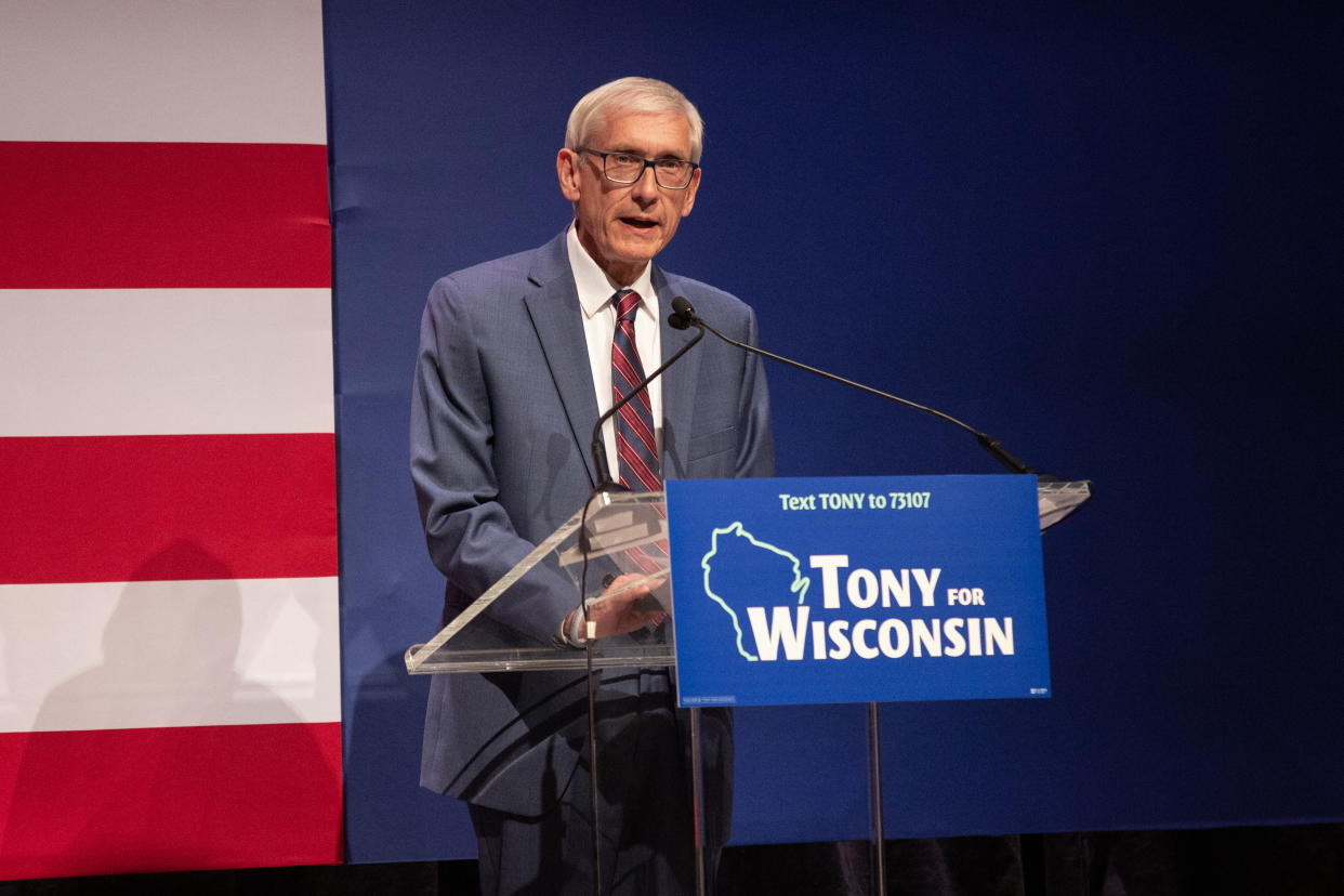 Gov. Tony Evers speaks to supporters a a podium saying Tony for Wisconsin.