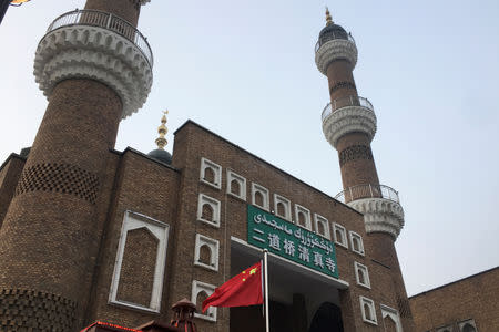 FILE PHOTO: The Chinese national flag flies outside the mosque at the Xinjiang International Grand Bazar during a government organised trip in Urumqi, Xinjiang Uighur Autonomous Region, China, January 3, 2019. REUTERS/Ben Blanchard