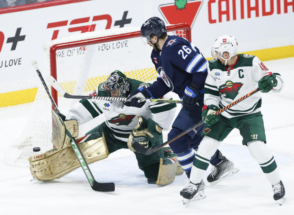 Minnesota Wild's Marc-Andre Fleury (29) saves the shot from Winnipeg Jets' Blake Wheeler (26) as Jared Spurgeon (46) defends during the second period of an NHL hockey game, Wednesday, March 8, 2023 in Winnipeg, Manitoba. (John Woods/The Canadian Press via AP)
