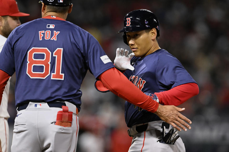 Boston Red Sox's Masataka Yoshida, right, reacts on first base after hitting a single against the Los Angeles Angels during the third inning of a baseball game in Anaheim, Calif., Friday, April 5, 2024. (AP Photo/Alex Gallardo)