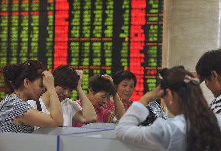 Investors react as they look at computer screens showing stock information at a brokerage house in Fuyang, Anhui province, REUTERS/Stringer