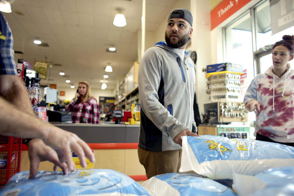 Christian and Kaitlyn Rosado were among hundreds of customers picking up supplies at the Marina Shores Taylor's Do It Center in Virginia Beach, Va., on Thursday, Jan. 20, 2022, in preparation for the impending winter storm. (Stephen M. Katz/The Virginian-Pilot via AP)