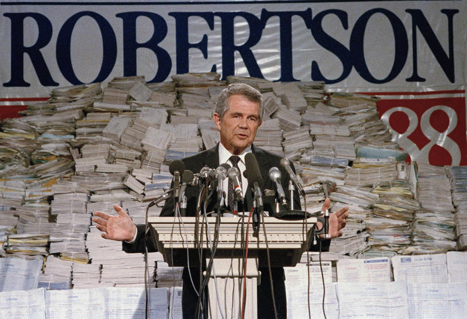 FILE - Pat Robertson, stands in front of stacks of signatures as he announced his intentions to collect a total of 7 million signatures during a news conference on Sept. 15, 1987 in Chesapeake, Va. Robertson, a religious broadcaster who turned a tiny Virginia station into the global Christian Broadcasting Network, tried a run for president and helped make religion central to Republican Party politics in America through his Christian Coalition, has died. He was 93. Robertson's death Thursday, June 8, 2023 was announced by his broadcasting network. (AP Photo/Steve Helber, file)