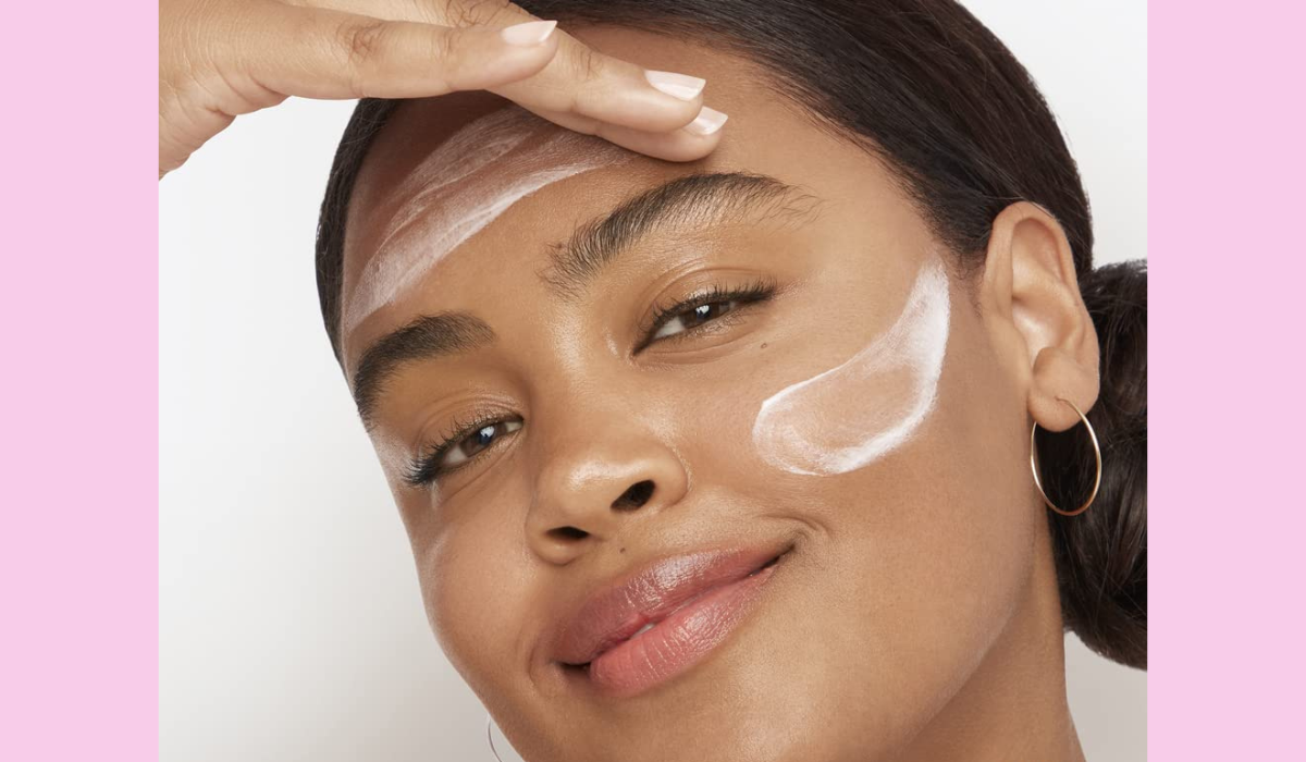 model applying the olay night cream to their face