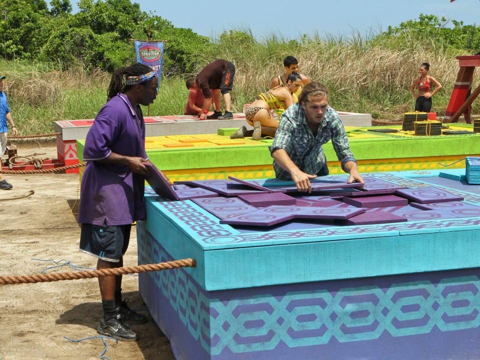 Russell Swan and Malcolm Freberg solving a purple and blue puzzle on survivor