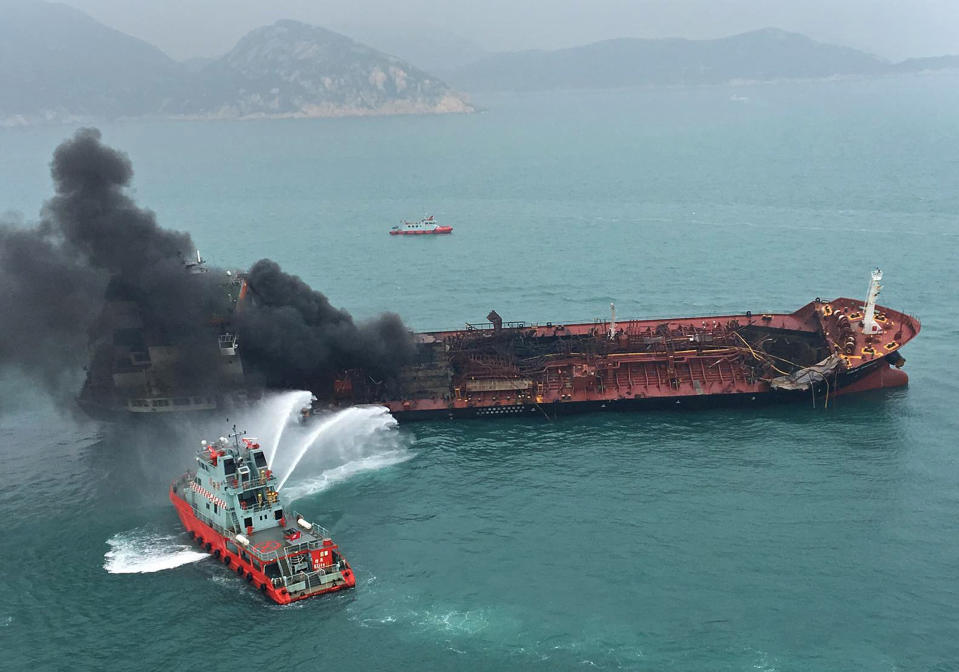 In this photo released by Hong Kong Government Flying Service, black smoke billows from an oil tanker after catching fire off southern Lamma island of Hong Kong, Tuesday, Jan. 8, 2019. Hong Kong fire officials say an oil-tanker explosion has killed one person and left three missing at sea. Authorities said Tuesday that a Vietnam-registered oil tanker burst into flames about 11:30 a.m. as it prepared to refuel at an anchorage off Hong Kong's southern coast. (Hong Kong Government Flying Service via AP)
