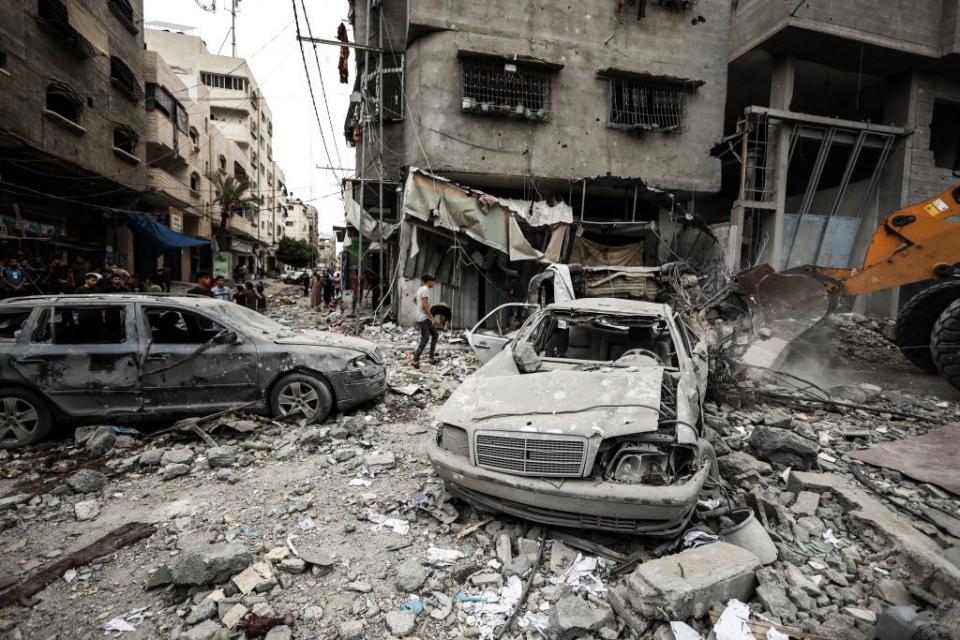 The rubble of destroyed buildings and cars dot Gaza City after an Israeli airstrike.