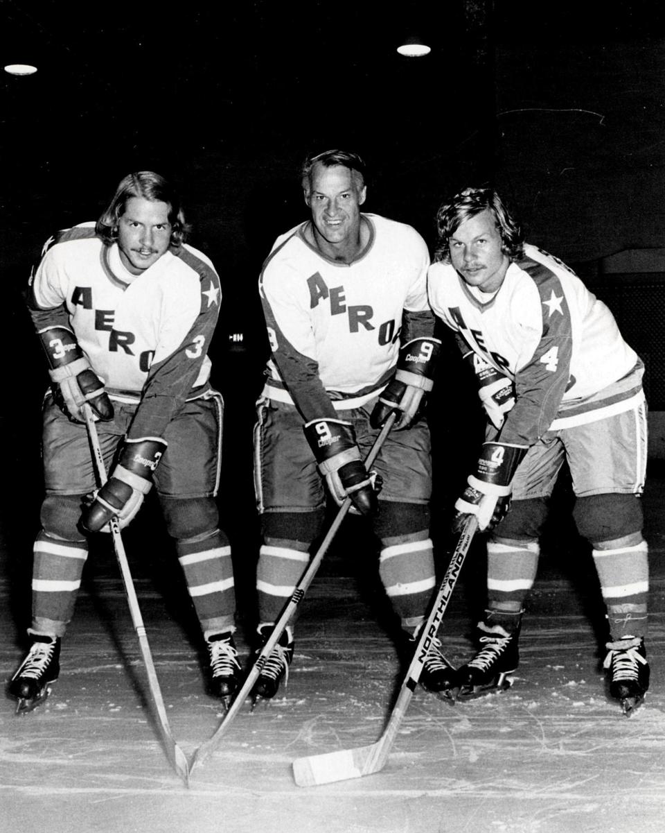 FILE - In this Aug. 3, 1973, file photo, former Detroit Red Wings great Gordie Howe, center, is flanked by sons Marty, left, and Mark as they try their new Houston Aeros uniforms in St. Clair Shores, Mich.
